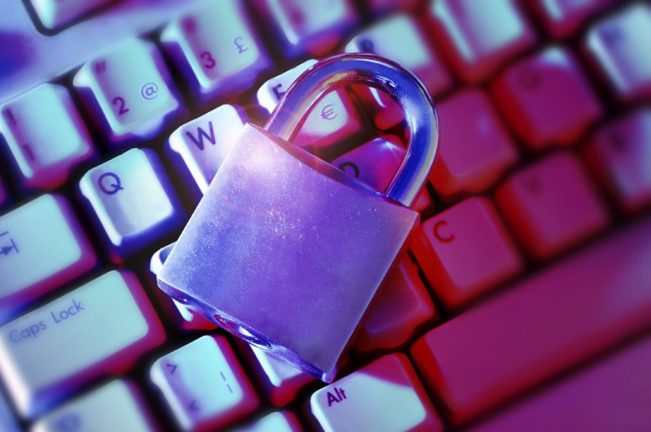 computer security A padlock resting on a computer keyboard with neon lighting.