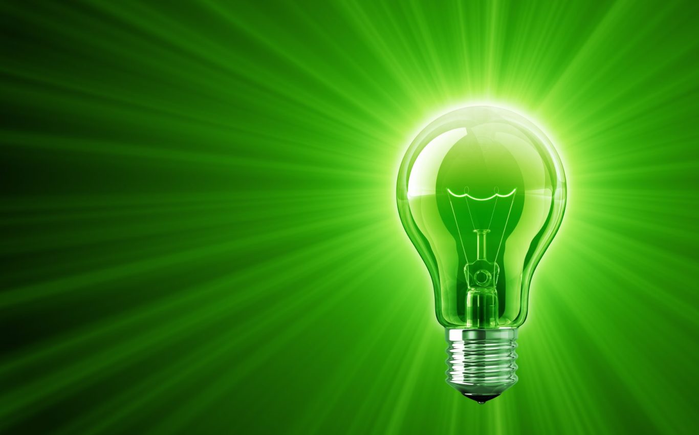 Bright green light bulb emitting rays of light against a darker green background.