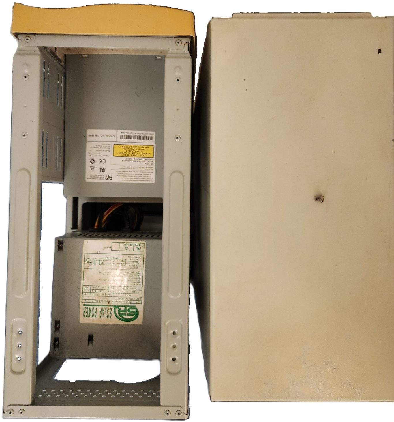 A gray electronic device with an open front panel, revealing internal components.